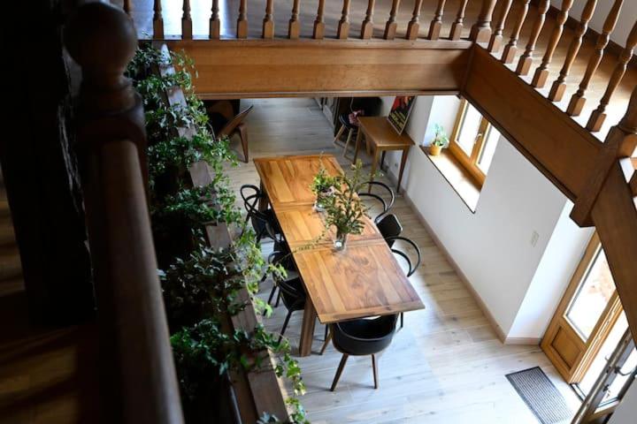an overhead view of a wooden table and chairs with plants at Gîte à l'origine in Montgesoye