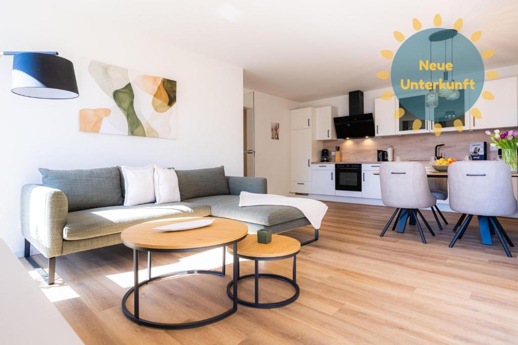 a living room with a couch and tables and a kitchen at Strandläufer 1 4 - Kellenhusen in Kellenhusen