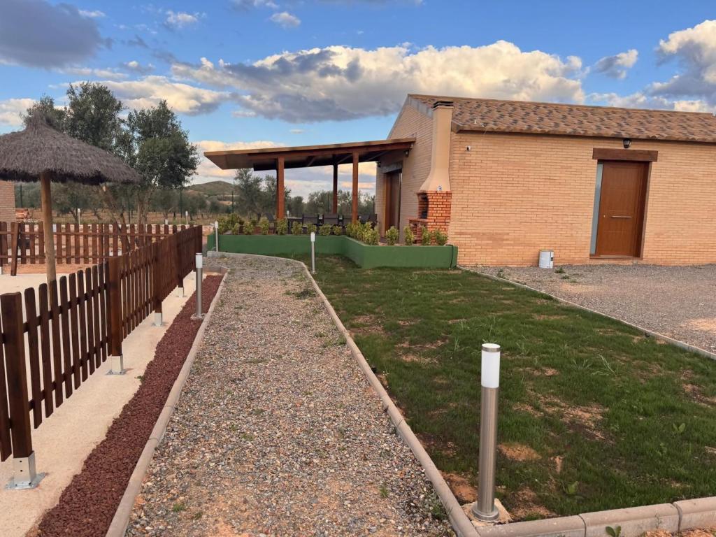 a garden in front of a building with a fence at Complejo Rural Santa Emma in Herencia