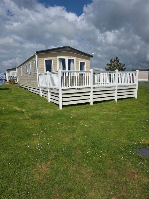 a house with a white fence in a yard at Bude 20 in Newquay