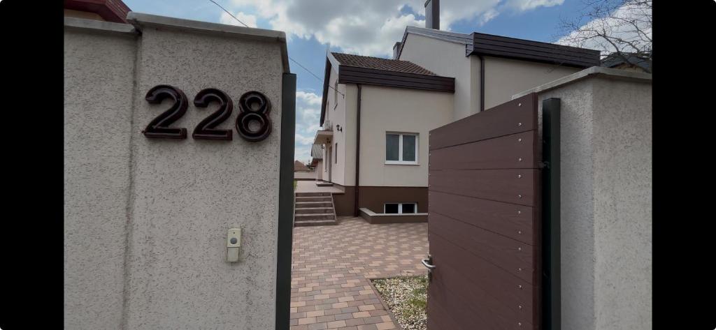 a house with a gate with the number on it at Budapest Airport Smart panzio in Vecsés