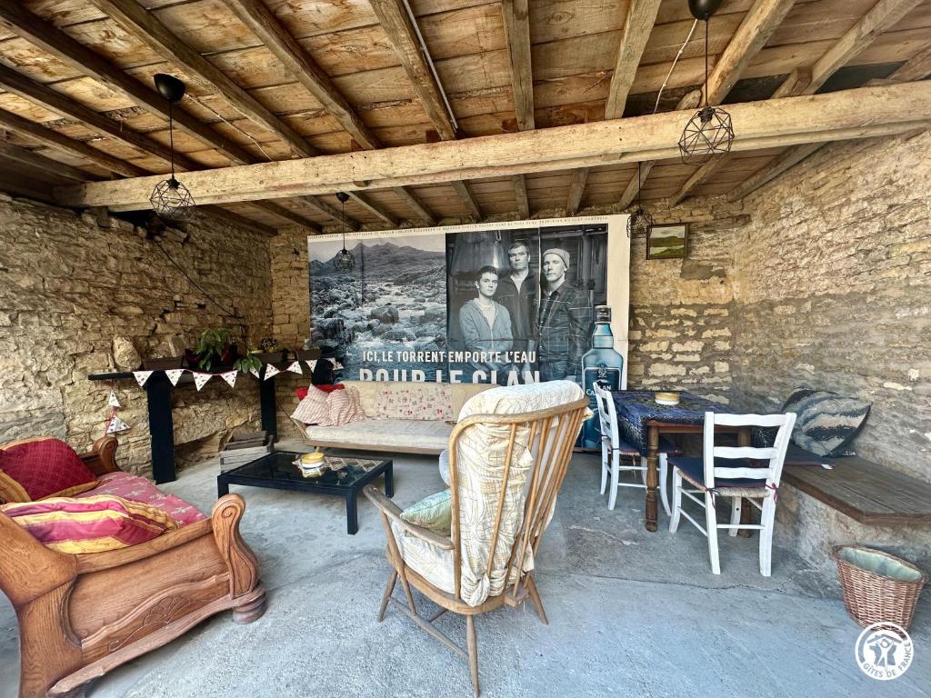 a living room with a couch and a table and chairs at Gîte Geoffroy in Montigny-sur-Aube