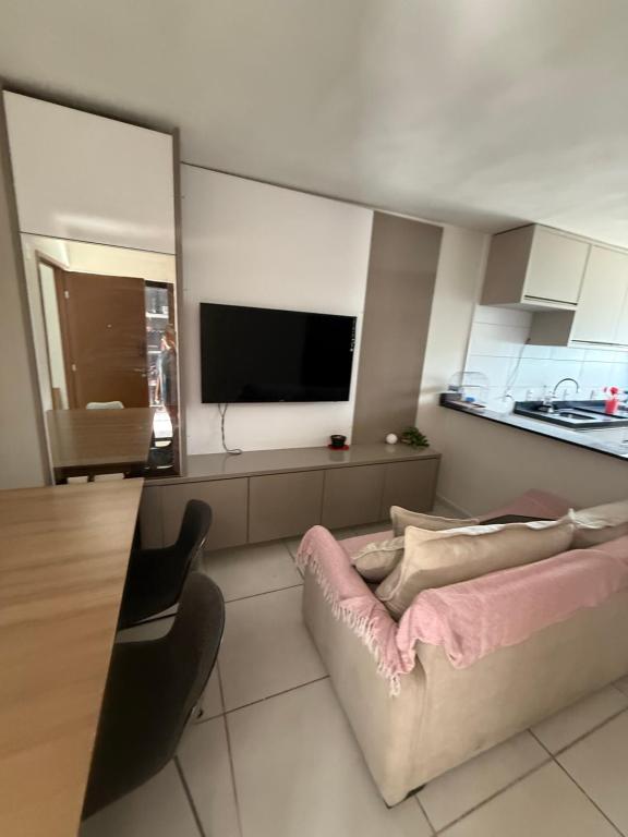 a living room with a couch and a flat screen tv at Conforto103 in Caruaru