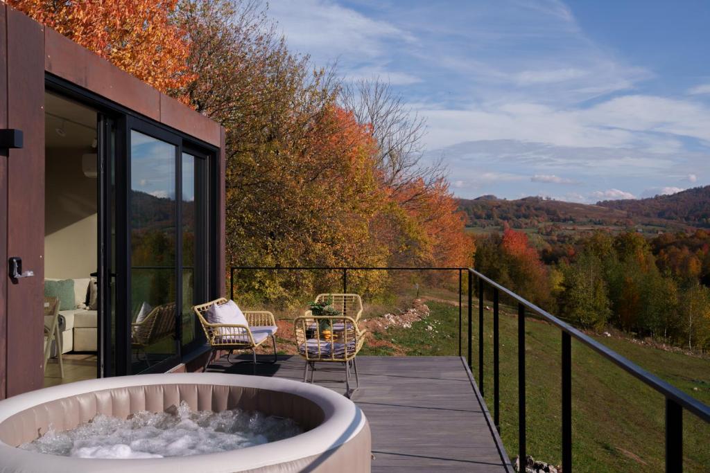 a hot tub on a deck with a view of the mountains at Coniferis in Tomnatic