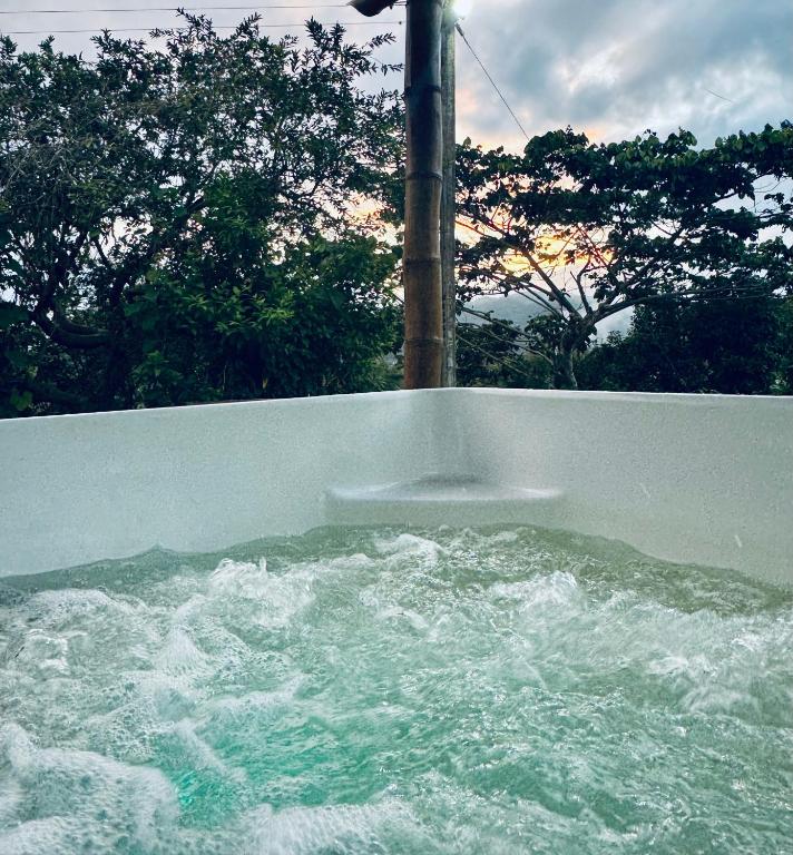 a tub filled with water with trees in the background at Jacuzzi - flores en la colina 2 in Bellavista