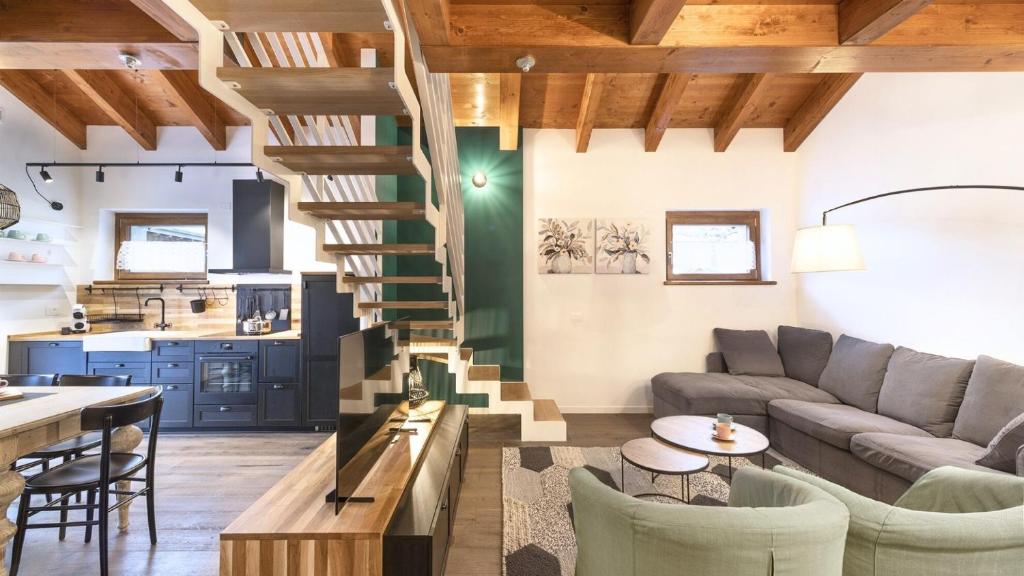 a living room with a couch and a spiral staircase at Sesto Senso in Ponte di Legno