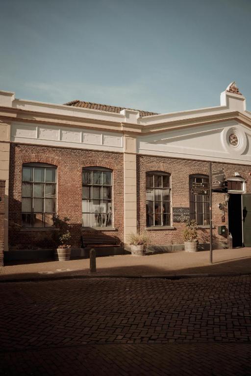a brick building with windows on a street at Boutique Hotel De Oude Veste in Hellevoetsluis