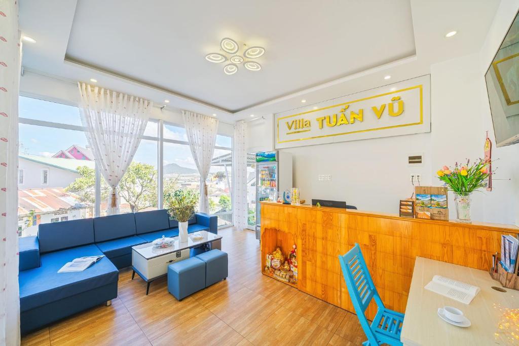 a restaurant with blue couches and a table and chairs at Villa Tuan Vu Da Lat in Da Lat