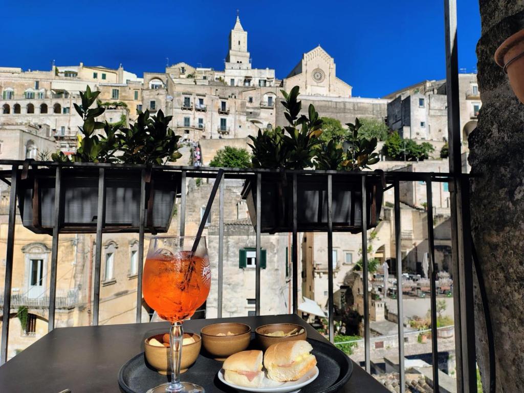 a table with sandwiches and a drink on a balcony at San Giovanni Vecchio - Residenza in Matera