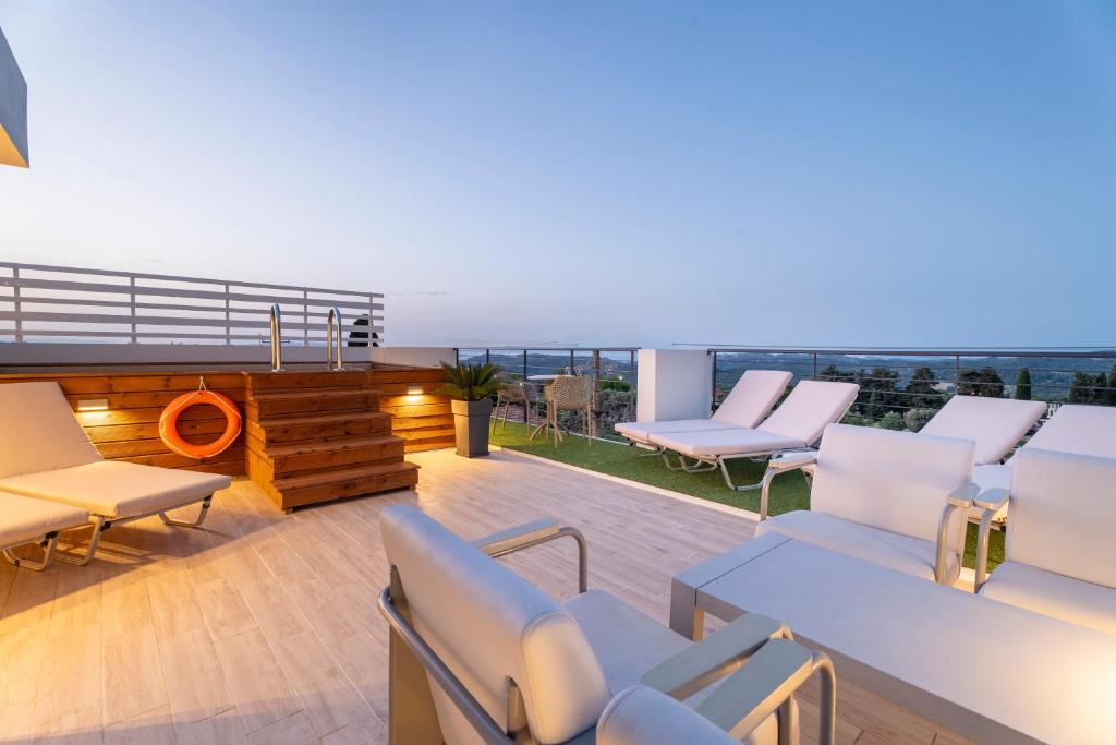 a patio with white furniture and a view of the ocean at Naiades Guest House in Sálakos