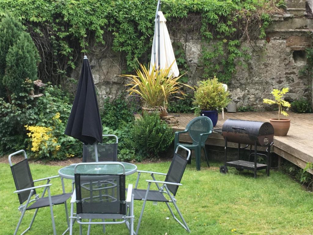 a group of chairs and a table and an umbrella at Cottage Sleeps 4 with Wifi in Llanfairpwllgwyngyll