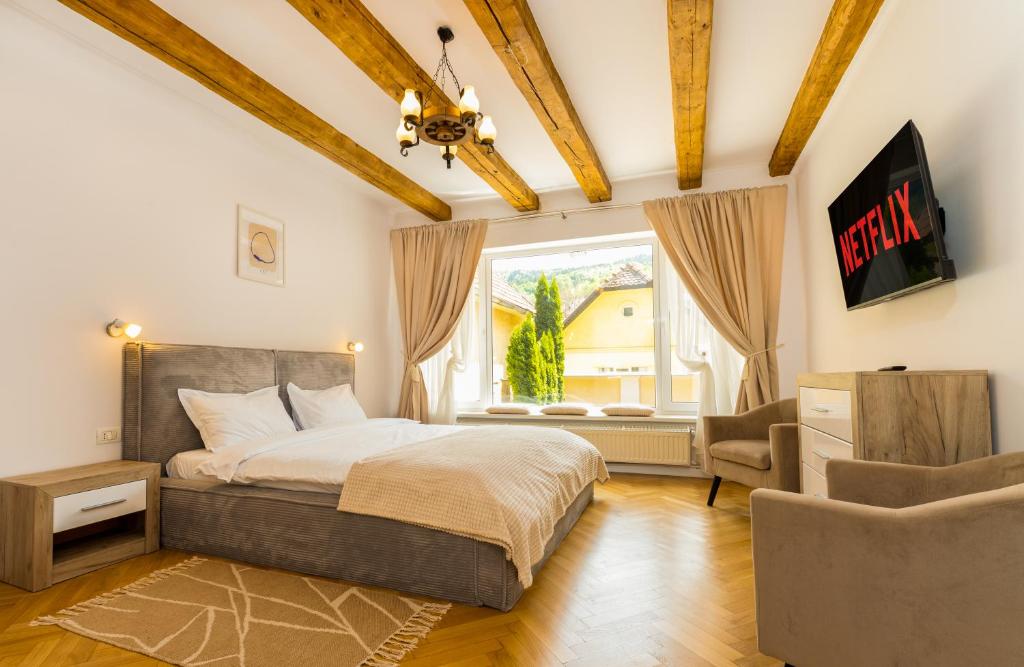a bedroom with a bed and a window at The Bucket - Calla Old Town House with Jacuzzi & View in Braşov