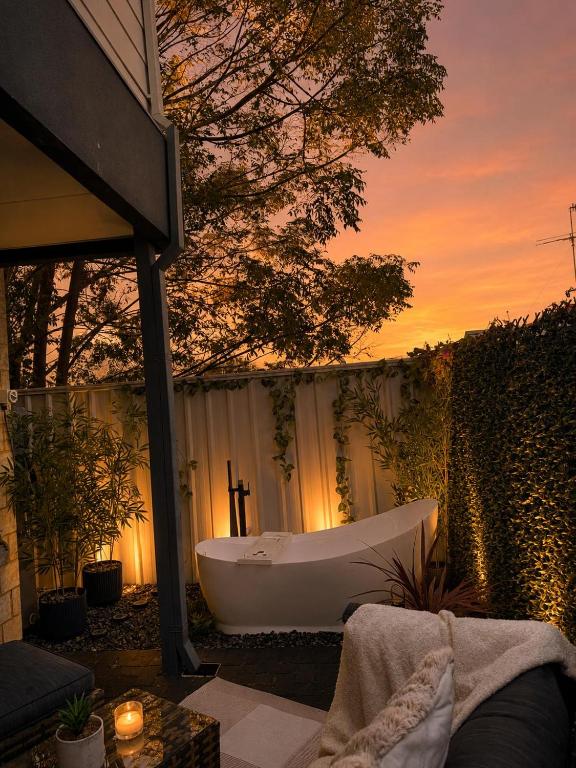 a bath tub sitting on a patio with a sunset at Glamorous Getaway in Mandurah