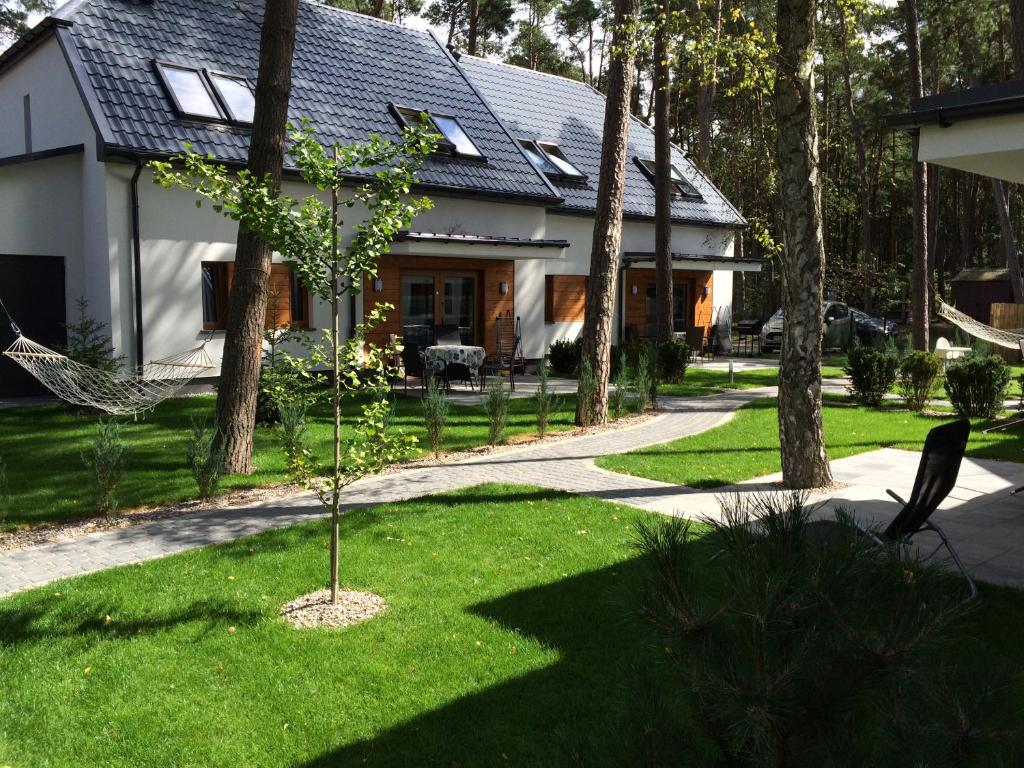 a house with a tree in the front yard at Apartamenty Villa Baltic Sun II i III in Międzywodzie