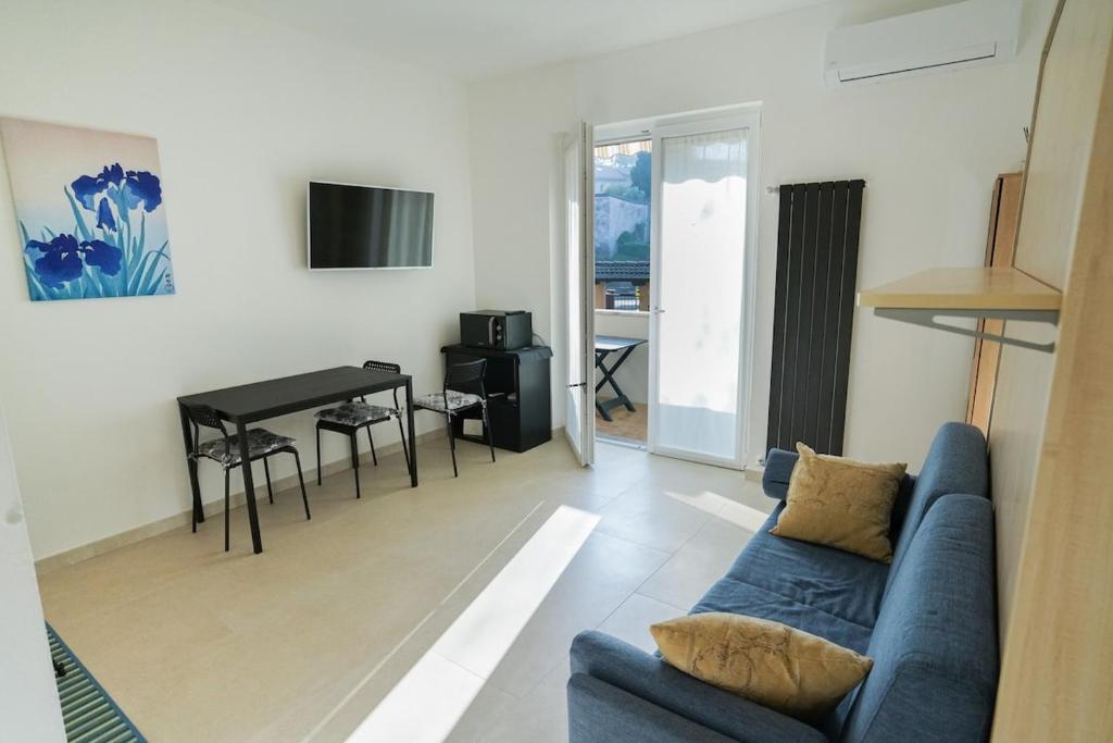 a living room with a blue couch and a table at Blue Iris - Varese - Laghi Svizzera in Varese