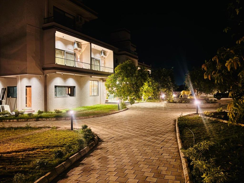a building at night with lights on the driveway at Vantara Gir Resort in Sasan Gir