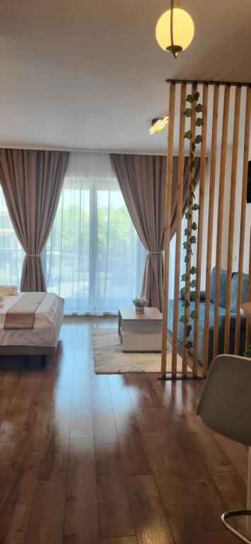 a bedroom with a bed and a staircase with windows at Garsoniera Daria in Saturn
