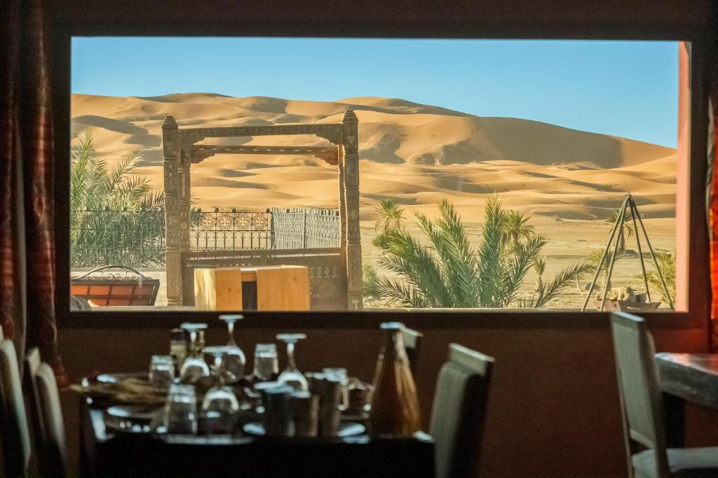 a view of a desert from a table in a restaurant at Hotel Riad Xaluca in Merzouga