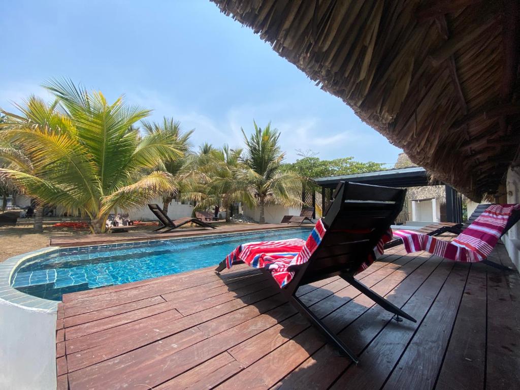 a deck with two lounge chairs next to a swimming pool at Hot Chipilin El Paredon in Sipacate