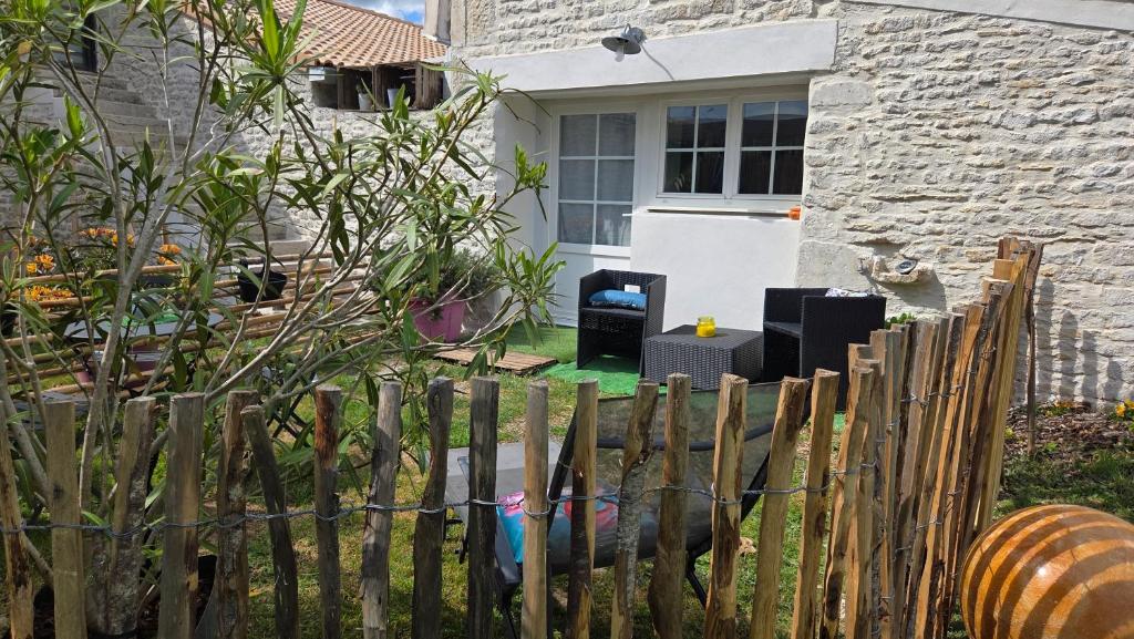 a wooden fence in front of a house at "Un aparté bohême" le STUDIO in Puyravault