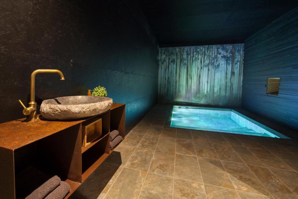 a bathroom with a sink and a swimming pool at SUITE TESORO climatisée avec piscine spa hammam et jardin avec piscine in Saint-Martial-sur-Né