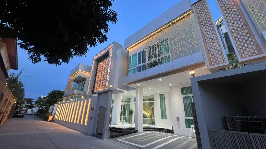 a large white building with glass doors on a street at IP on HOME 1 in Jomtien Beach