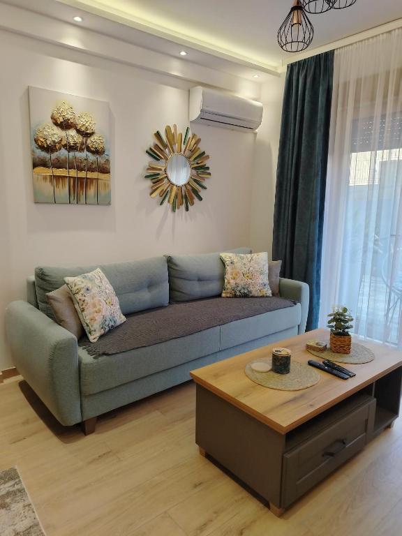 a living room with a blue couch and a coffee table at Apartman Amber Vrnjačka Banja in Vrnjačka Banja