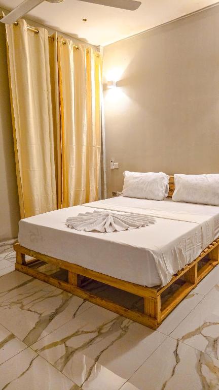 a bed in a room with a wooden frame at 7G Residency Bwejuu in Bwejuu