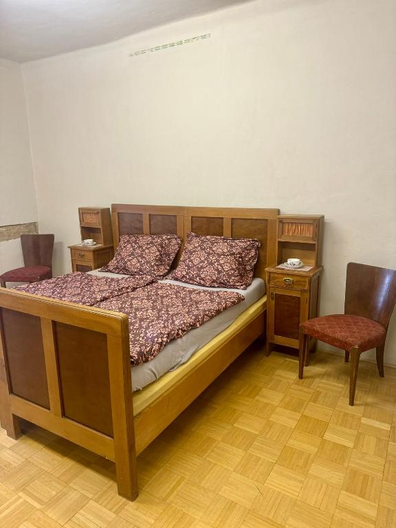 a bedroom with a wooden bed and a chair at Zámek Hošťálkovy in Hošťálkovy