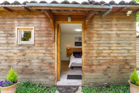 a wooden house with a door leading to a bedroom at Tiny House de Charme & Oasis Privée in Toulouse