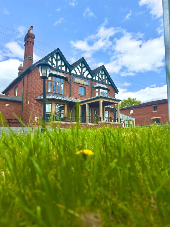 a large brick building in front of a field of grass at Staindrop Hotel in Sheffield