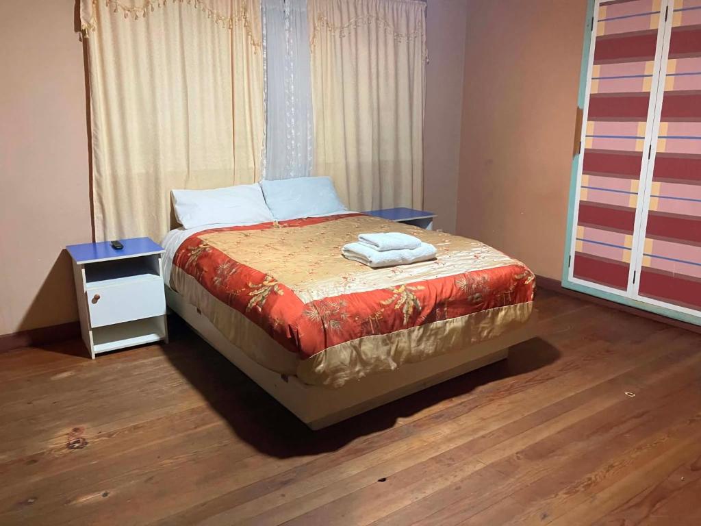 a bedroom with a bed with a nightstand and a bed sidx sidx at Imperio Carlos V in Oruro