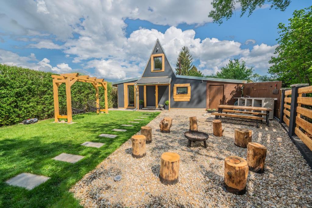 a house with a garden with logs in the yard at Chata Björk in Babice