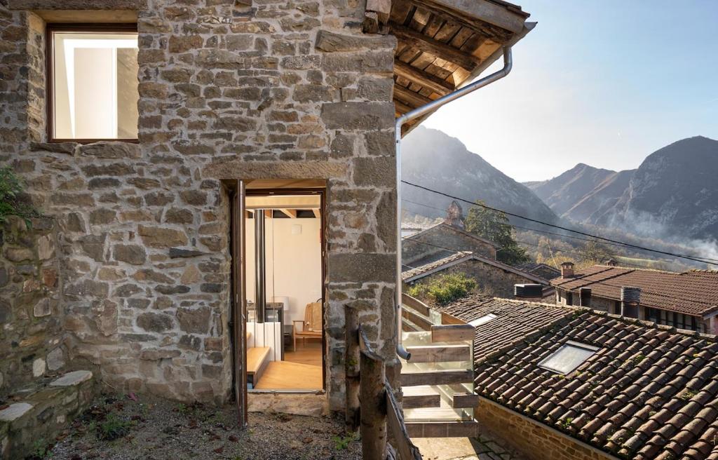 a stone house with a view of the mountains at Benaki 99 in Ladines
