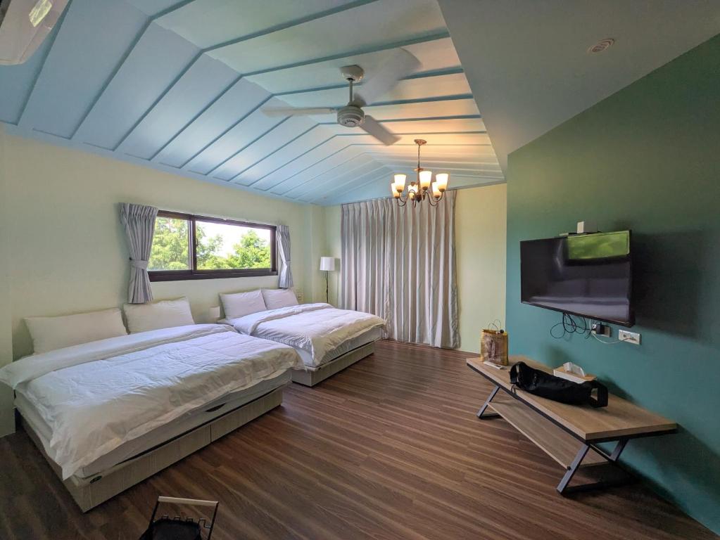 a bedroom with two beds and a flat screen tv at 羅東夏林5號 in Luodong