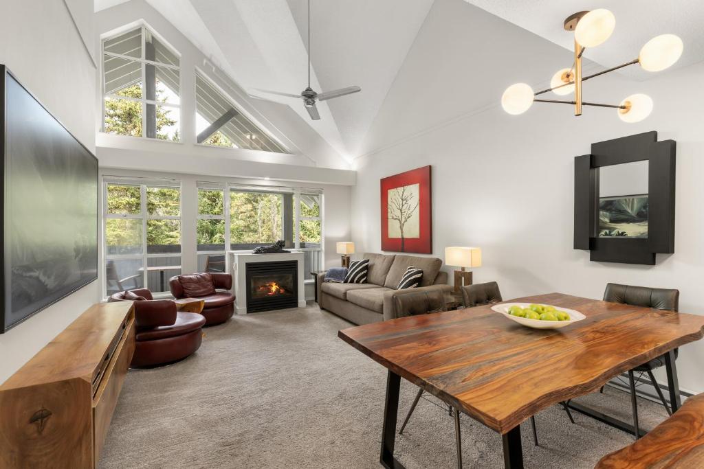 a living room with a table and a fireplace at Glacier Lodge in Whistler