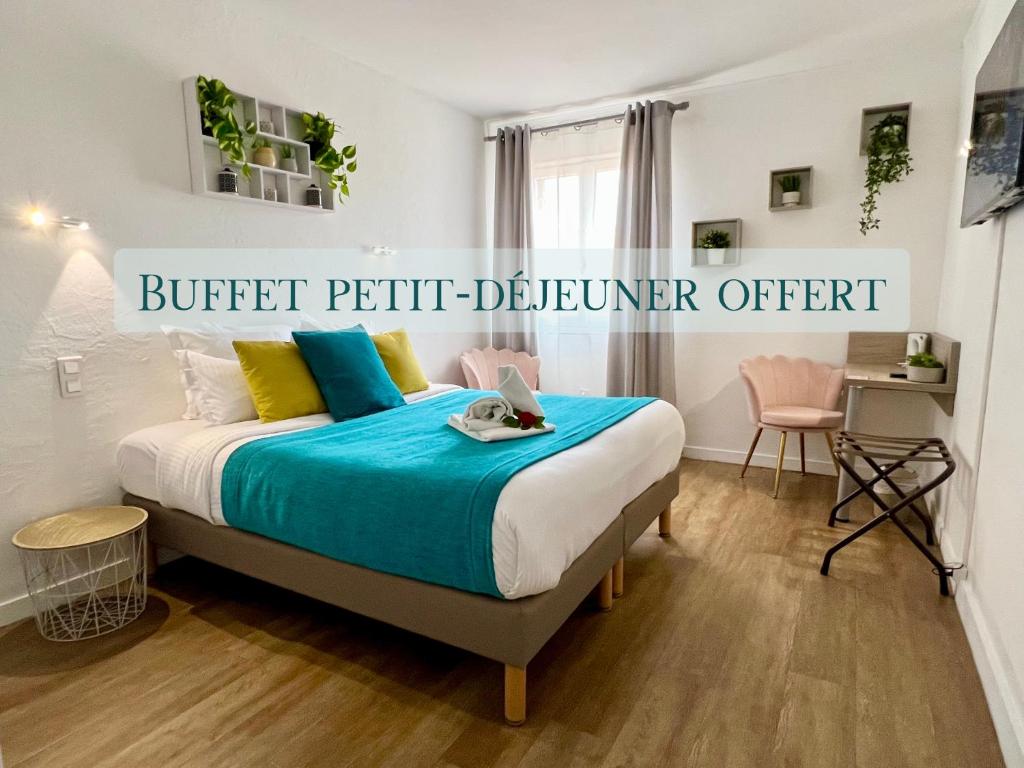 ein Schlafzimmer mit einem Bett mit einer blauen Decke in der Unterkunft Hotel L'Escapade in Le Lavandou