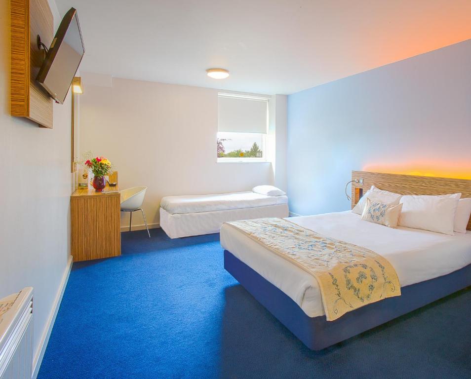 a bedroom with a bed and a desk at Redwings Lodge Wolverhampton Central in Wolverhampton