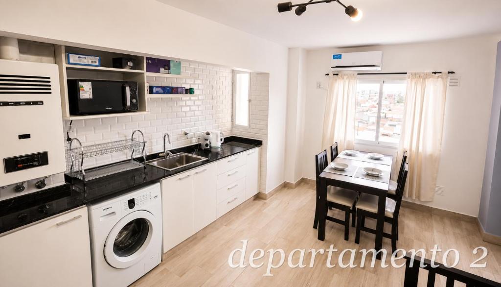 a kitchen with a sink and a table with a washing machine at Nice Full Apartments Downtown Salta in Salta