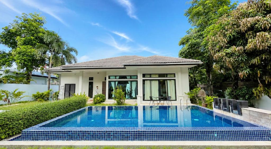 a villa with a swimming pool in front of a house at MYSA 3bed Pool Villa Near Central Phuket Bang Tao in Phuket