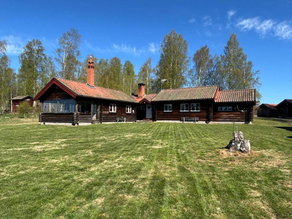 a log cabin with a large yard in front of it at Lake Lodge Rönnäs in Leksand
