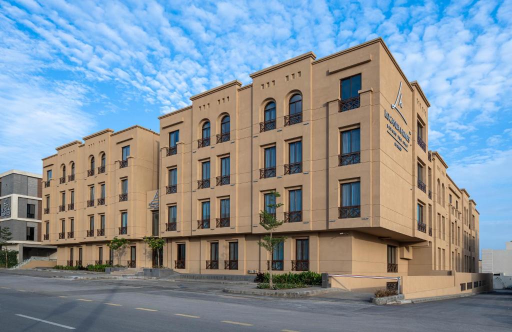 a large tan building on the side of a street at Locanda Homes by Jareed لوكاندا هومز باي جريد in Riyadh