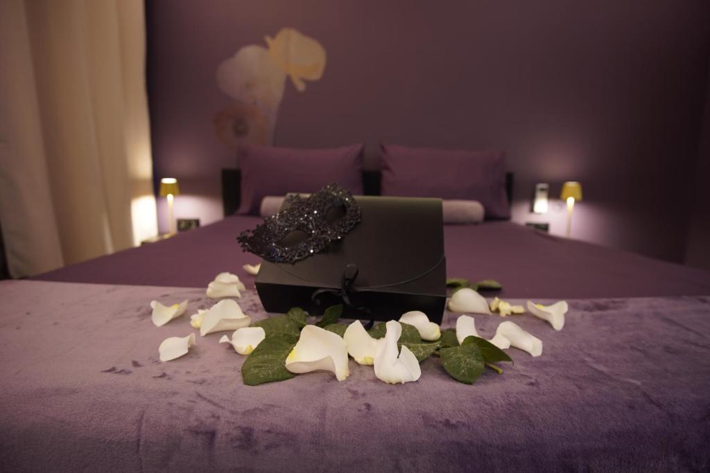 a pile of flowers on a bed with a box at La Muse Ment - Suite La Valtesse de la Bigne in Liège