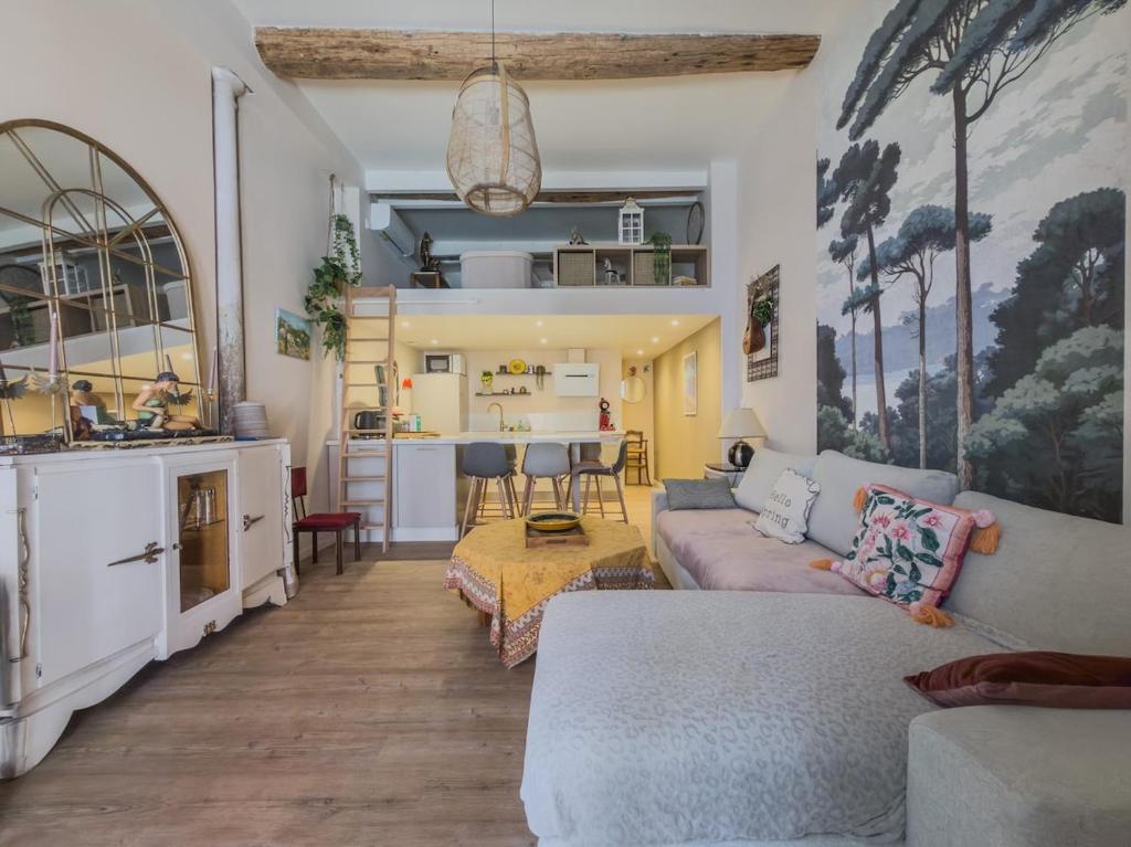 a living room with a couch and a kitchen at L'échappée in Collobrières