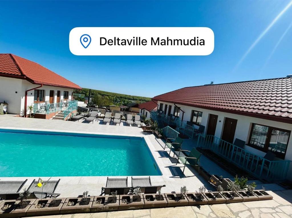 a view of a swimming pool with chairs and a building at Deltaville in Mahmudia