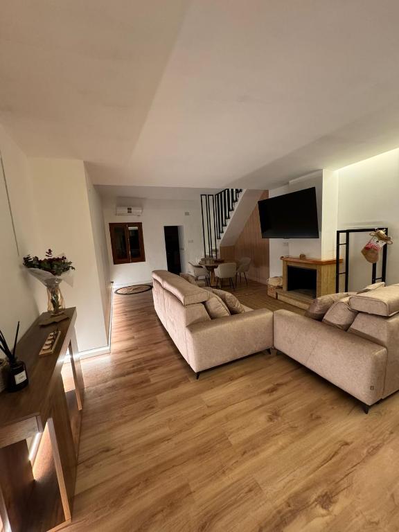 a living room with two couches and a television at Raíces del Noroeste in Caravaca de la Cruz