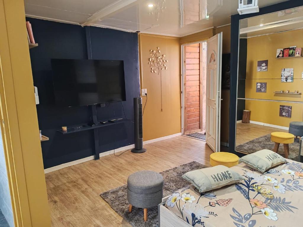 a living room with two beds and a flat screen tv at Loc 'FCathy in Saint-Benoît