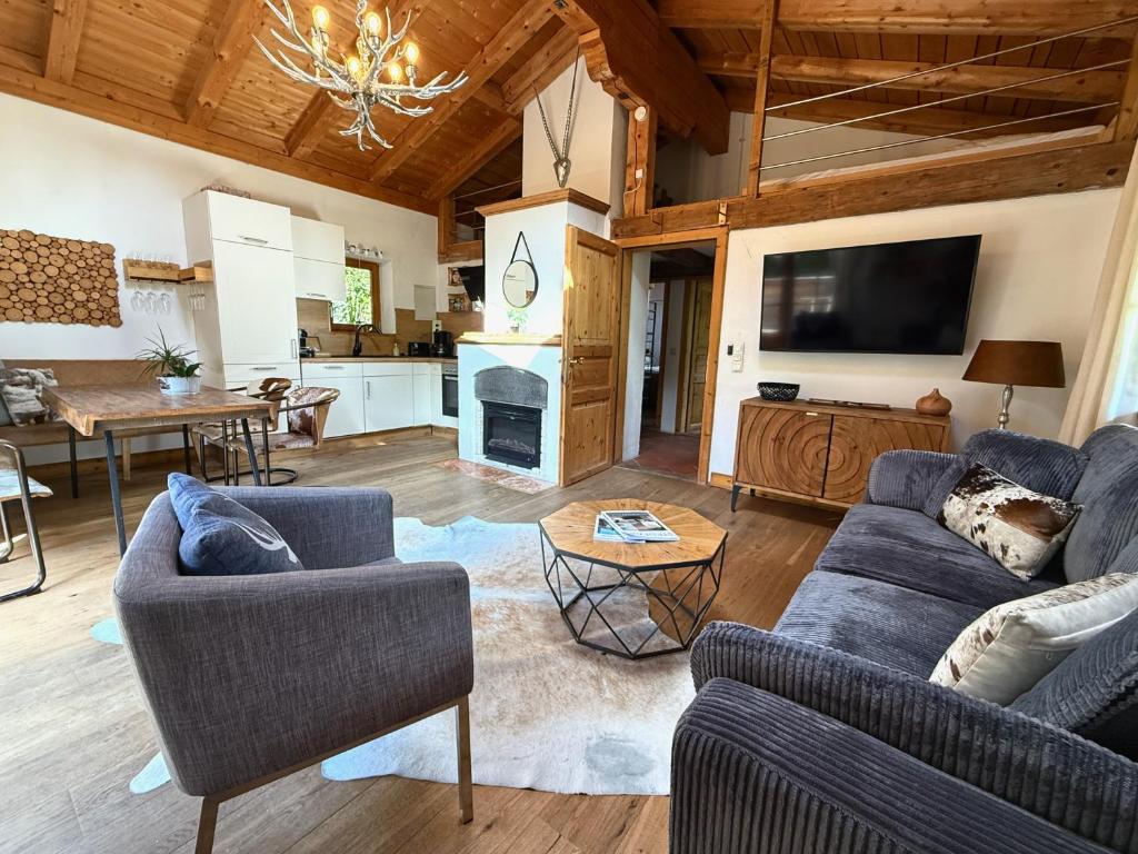 a living room with two couches and a tv at CHALET BELLE KITZ by Belle Stay in Kitzbühel