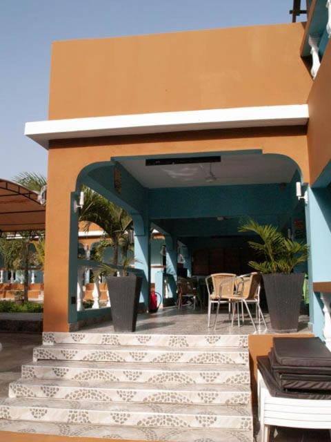 a building with a patio with tables and chairs at Amerix resorts and adventures in Diani Beach