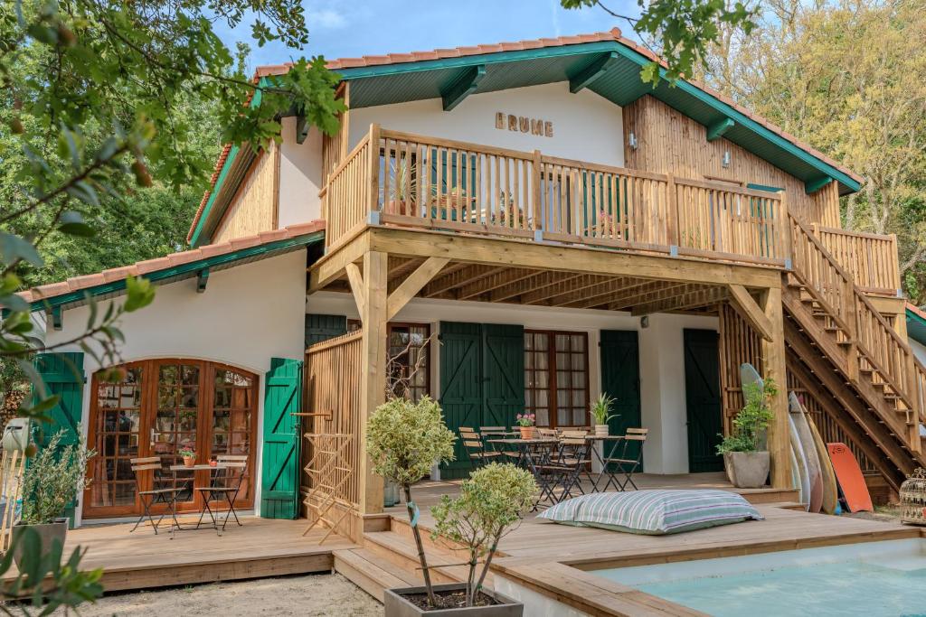 a house with a deck and a pool at Brume Surf House in Messanges